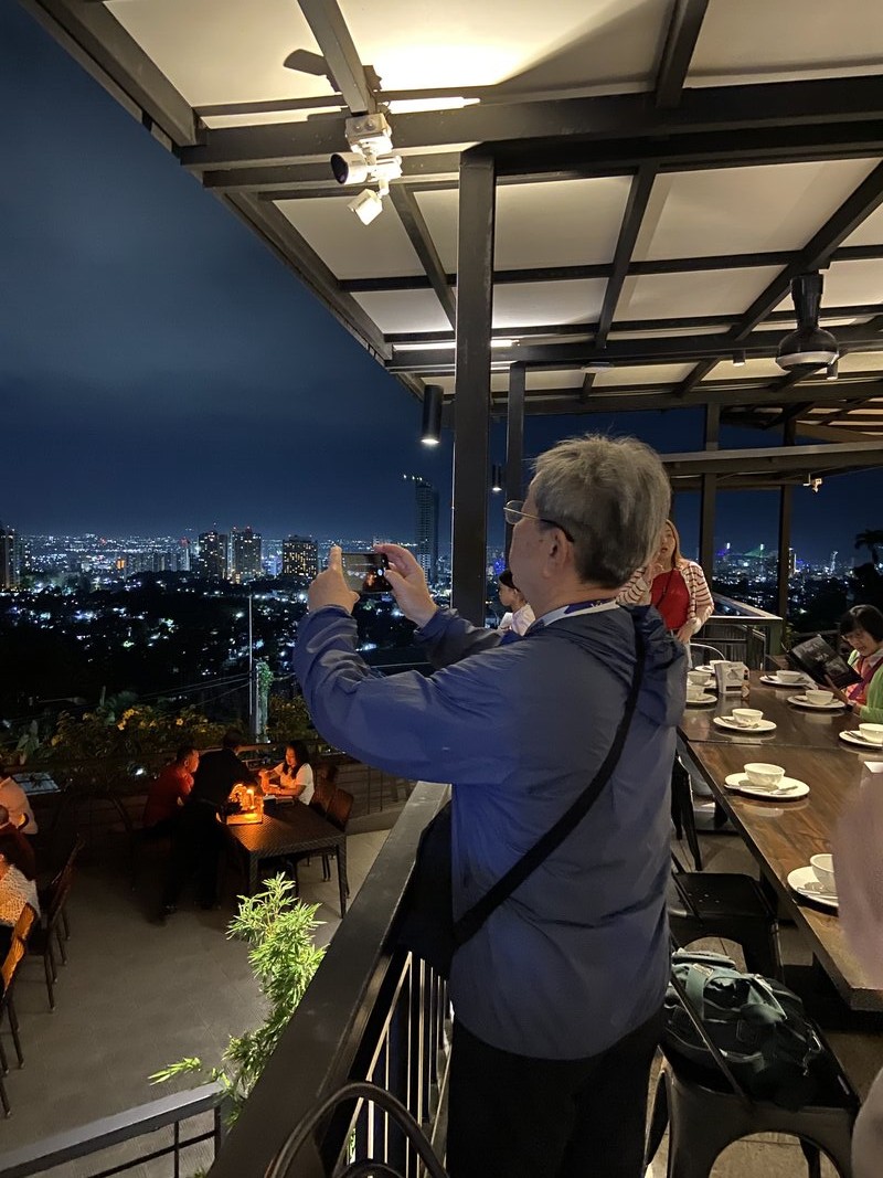 ゴールデンエイジ・スタディツアーの参加者がセブ市内の夜景を一望するルーフトップディナーを楽しむ